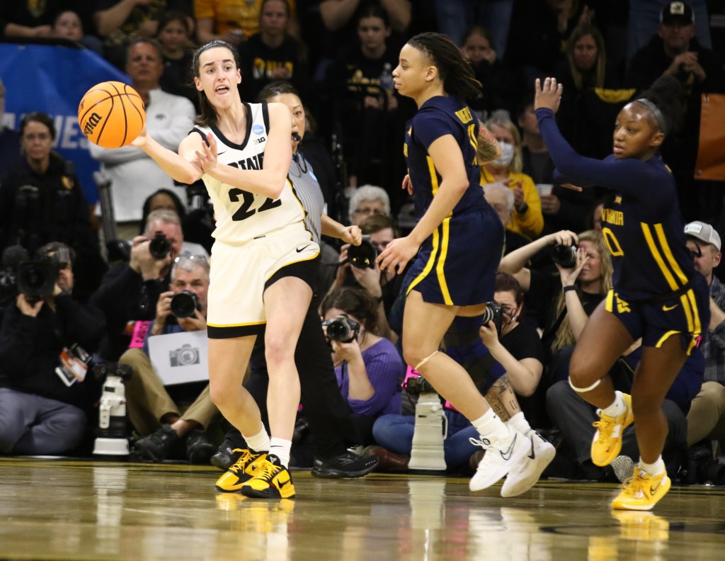 Iowa guard Caitlin Clark (22) passes the ball against West Virginia on March 25, 2024.